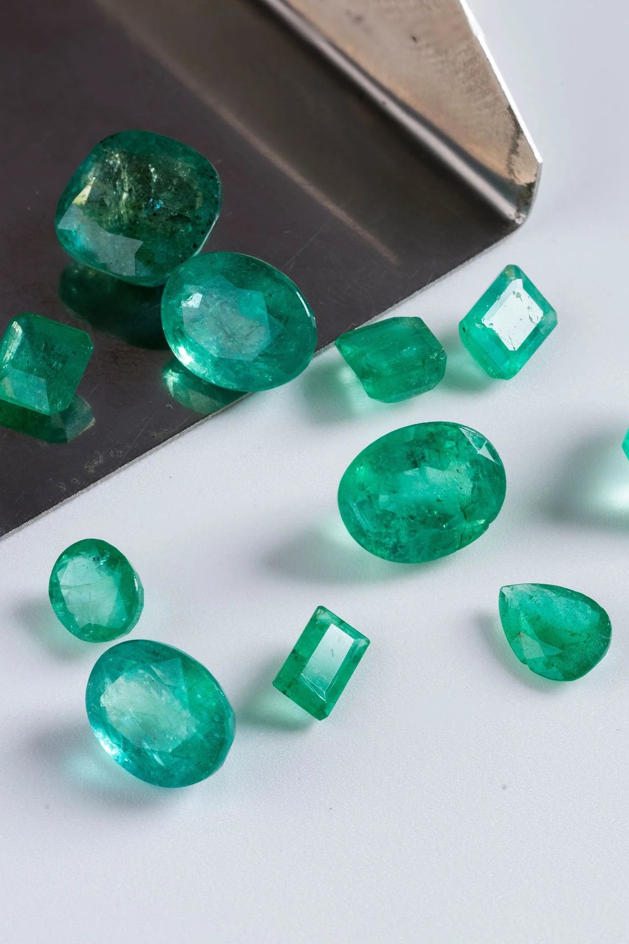 Emerald gemstones on a reflective surface
